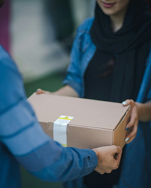 man handing package to woman