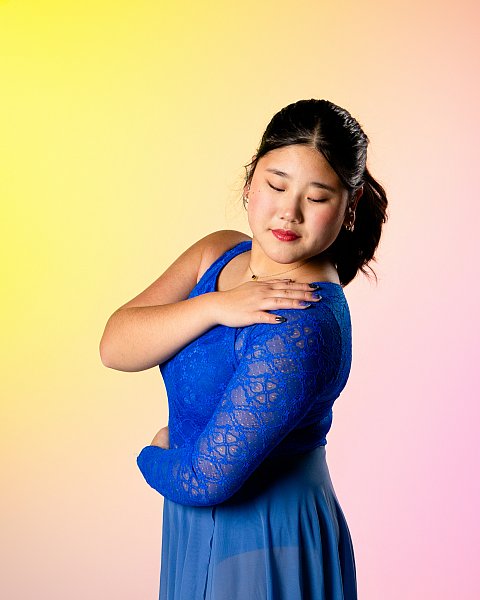 Teenage girl figure skating sports portrait with sunset lighting and blue dress.