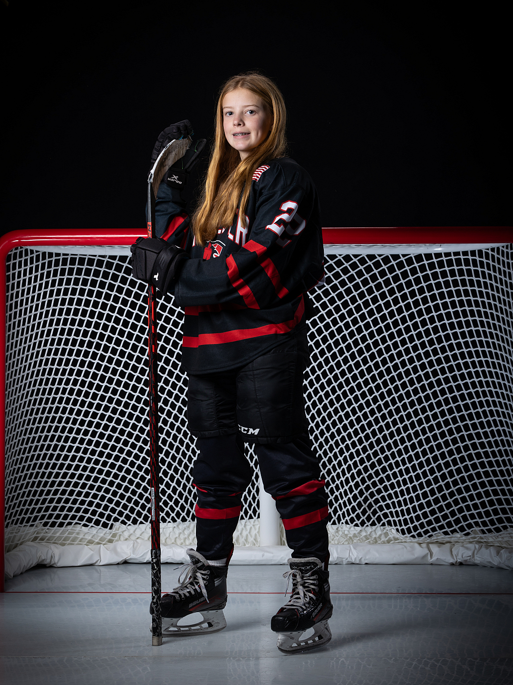 MN Girls Hockey Sports Portrait with goal in background.