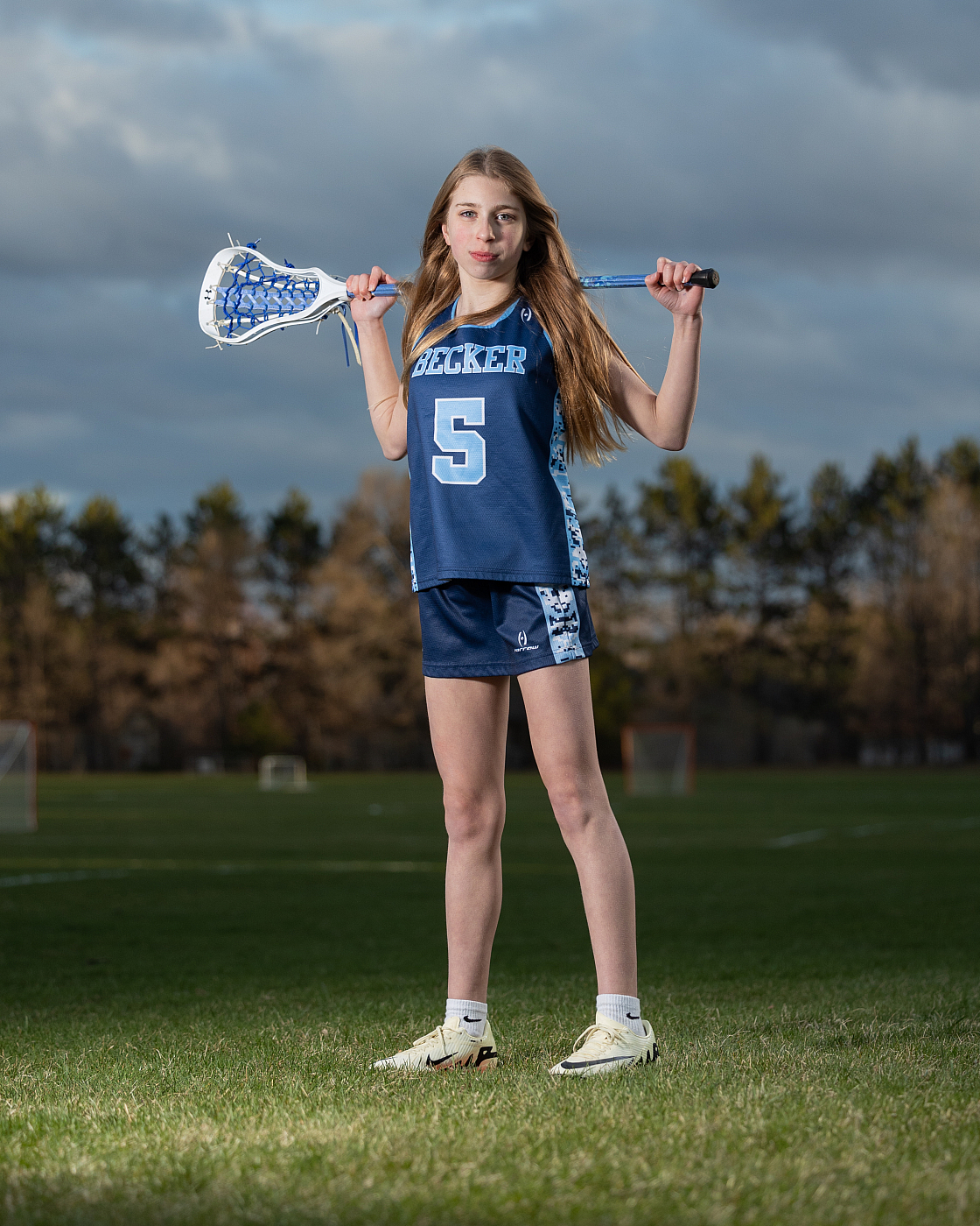 Becker girl holding lacrosse stick for her outdoor individual lacrosse sports portrait