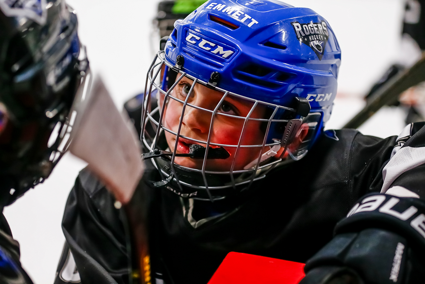 boy hockey player candid headshot of face with helmet on during timeout blue helmet