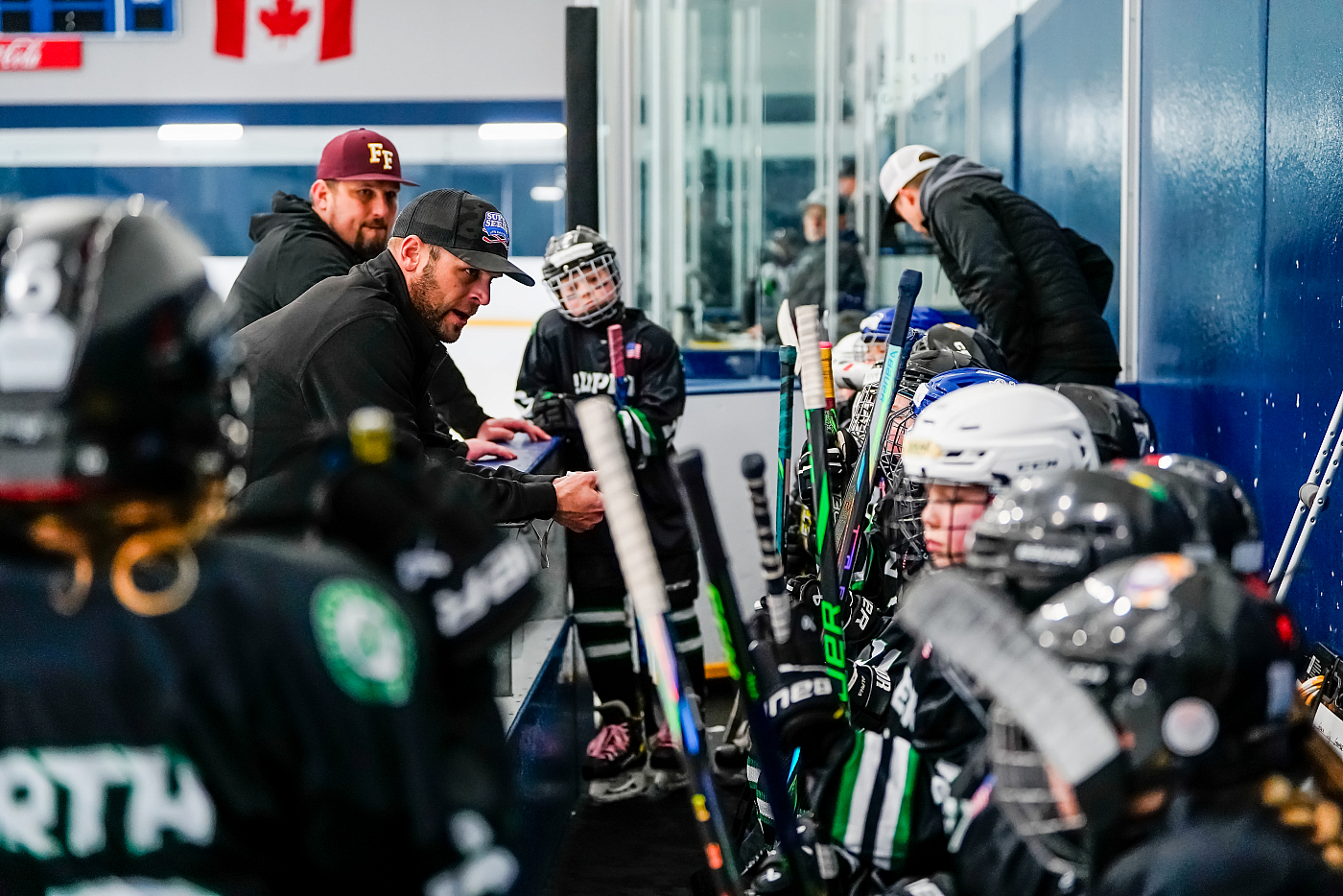 hockey coach talking to boys hockey team during timeout during hockey game