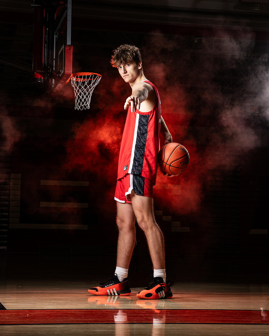 high school male basketball player with basketball red smoke background
